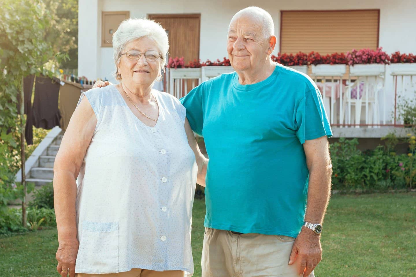 Elderly couple standing in sunny garden