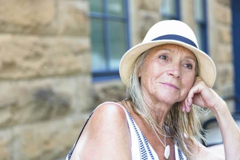 Elderly woman smiling in sun hat outdoors